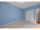 Bedroom features light carpet, light blue walls, a closet and a view into an en-suite bathroom at 1614 E Hardscrabble Dr, Hillsborough, NC 27278