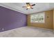 Neutral bedroom with tray ceilings, ceiling fan, plush carpet, and large bright window at 1614 E Hardscrabble Dr, Hillsborough, NC 27278