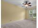 Sunny bedroom features neutral carpet, yellow walls, a ceiling fan and natural light from the window at 1614 E Hardscrabble Dr, Hillsborough, NC 27278