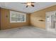 Light-filled bedroom offering neutral walls, soft carpet, tray ceiling, and access to an ensuite bath at 1614 E Hardscrabble Dr, Hillsborough, NC 27278