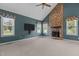 Cozy living room featuring a stone fireplace, ceiling fan, and large windows providing lots of light at 1614 E Hardscrabble Dr, Hillsborough, NC 27278