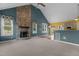 Open living room with a stone fireplace and large windows, flowing into the bright and sunny kitchen at 1614 E Hardscrabble Dr, Hillsborough, NC 27278