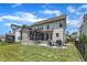 Inviting backyard featuring a patio with fire pit, screened porch, lush green lawn, and black metal fence at 1716 Aberdour Dr, Apex, NC 27502