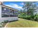 Enclosed sunroom with expansive backyard, lush green lawn, and shade trees at 1716 Aberdour Dr, Apex, NC 27502
