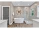 Modern bathroom featuring a free-standing tub, glass-enclosed shower, and wood-look tile floors at 1716 Aberdour Dr, Apex, NC 27502
