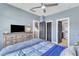 Bright bedroom featuring neutral blue walls, ceiling fan, and multiple doors at 1716 Aberdour Dr, Apex, NC 27502