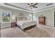 Bright bedroom featuring carpeted floors, tray ceiling, ceiling fan, and dual windows at 1716 Aberdour Dr, Apex, NC 27502