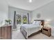 Cozy bedroom features a queen-size bed, natural light from a large window, and neutral decor at 1716 Aberdour Dr, Apex, NC 27502