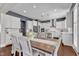 Charming dining area with a farmhouse table and chairs, with views into the kitchen and natural light at 1716 Aberdour Dr, Apex, NC 27502
