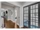 Hallway featuring hardwood floors, grey walls, and glass paneled doors at 1716 Aberdour Dr, Apex, NC 27502