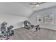 Bright home gym with carpet, multiple workout machines, a ceiling fan, and a window for natural light at 1716 Aberdour Dr, Apex, NC 27502