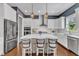 Beautiful kitchen with island seating, white cabinetry, stainless steel appliances, and designer pendant lighting at 1716 Aberdour Dr, Apex, NC 27502