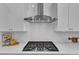 Close-up on a modern gas range with stainless steel hood and herringbone tile backsplash at 1716 Aberdour Dr, Apex, NC 27502