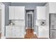Bright kitchen with white cabinetry, stainless steel appliances, and hardwood flooring at 1716 Aberdour Dr, Apex, NC 27502