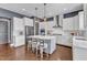 Open kitchen featuring white cabinets, island seating, pendant lights, and stainless steel appliances at 1716 Aberdour Dr, Apex, NC 27502