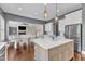 Bright kitchen features stainless appliances, island with white countertop, and view of living area at 1716 Aberdour Dr, Apex, NC 27502