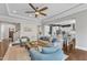 Bright living room with ceiling fan, hardwood floors, and stylish furniture open to the kitchen and dining area at 1716 Aberdour Dr, Apex, NC 27502