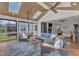 Bright sunroom featuring skylights, ceiling fans, and comfortable seating leading to the living room with fireplace at 1716 Aberdour Dr, Apex, NC 27502