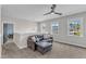 Open loft featuring a comfortable leather couch, a ceiling fan, and plenty of natural light at 1716 Aberdour Dr, Apex, NC 27502