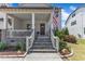 Inviting front porch with stone stairs, white railings, and a stained wood front door at 1716 Aberdour Dr, Apex, NC 27502