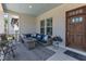 Cozy porch features a comfortable seating area, a modern rug, and a stained-wood front door at 1716 Aberdour Dr, Apex, NC 27502