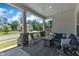 Relaxing covered porch with an outdoor seating area, stylish rug, and stone-covered columns at 1716 Aberdour Dr, Apex, NC 27502