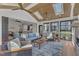 Bright sunroom with vaulted ceiling, skylights, fireplace, and comfortable furniture setup at 1716 Aberdour Dr, Apex, NC 27502