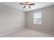 Bright bedroom with neutral carpet, ceiling fan, and a window providing natural light at 1966 Grassy Banks Dr, Raleigh, NC 27610