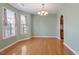 Dining room featuring wood floors, soft green walls, and a modern chandelier at 1966 Grassy Banks Dr, Raleigh, NC 27610