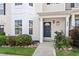 Charming townhouse entrance with a dark door, manicured landscaping, and well-lit porch at 1966 Grassy Banks Dr, Raleigh, NC 27610