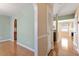 Well-lit hallway featuring hardwood floors, an arched doorway, and neutral paint at 1966 Grassy Banks Dr, Raleigh, NC 27610