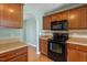 Cozy kitchen with wooden cabinets, black appliances, and tile backsplash at 1966 Grassy Banks Dr, Raleigh, NC 27610