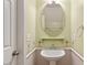 Charming powder room with pedestal sink, decorative mirror, and coastal-themed accents at 1966 Grassy Banks Dr, Raleigh, NC 27610