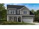 Charming two-story home with gray siding, white trim, covered porch and attached two car garage at 2009 Clydner Dr, Cary, NC 27523