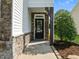 Elegant front door framed by stone accents and lush landscaping at 2036 October Dr, Durham, NC 27703