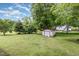 Backyard featuring green grass, trees, and a storage shed at 205 Person St, Oxford, NC 27565