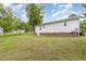 Backyard featuring green grass and the side of a white house with brick accents at 205 Person St, Oxford, NC 27565