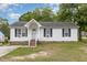 Charming single-story home with white siding, black shutters, and a well-manicured front yard at 205 Person St, Oxford, NC 27565