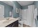 Cozy bathroom featuring a tub with shower, vanity, and soft blue walls at 205 Willow Weald Ct, Fuquay Varina, NC 27526