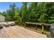 Large backyard deck surrounded by green trees, offering privacy and outdoor entertaining space at 205 Willow Weald Ct, Fuquay Varina, NC 27526