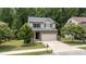 Two-story home featuring a stone facade, a two-car garage, and mature trees at 205 Willow Weald Ct, Fuquay Varina, NC 27526