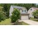 View of a two-story home featuring manicured landscaping and a stone and siding exterior at 205 Willow Weald Ct, Fuquay Varina, NC 27526