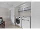 Laundry closet featuring a front-load washer, dryer, and shelving for storage at 205 Willow Weald Ct, Fuquay Varina, NC 27526