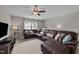 Spacious living room with a large sectional sofa, a ceiling fan, and natural light at 205 Willow Weald Ct, Fuquay Varina, NC 27526