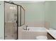 Bright bathroom featuring tiled shower with glass door and a soaking tub, exuding comfort and style at 215 Dungarven Loop, Cary, NC 27513