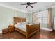 Relaxing bedroom with hardwood floors, a large bed, and a bright window at 215 Dungarven Loop, Cary, NC 27513