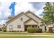 Beige two-story home showcasing a well-manicured lawn and tidy landscaping at 215 Dungarven Loop, Cary, NC 27513