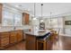 Bright kitchen featuring an island with bar seating, hardwood floors, and stainless steel dishwasher at 215 Dungarven Loop, Cary, NC 27513