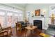 Cozy living room featuring hardwood floors, a fireplace, and ample natural light from the windows at 215 Dungarven Loop, Cary, NC 27513