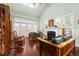 Bright living room featuring hardwood floors, a fireplace, and large windows with white shutters at 215 Dungarven Loop, Cary, NC 27513